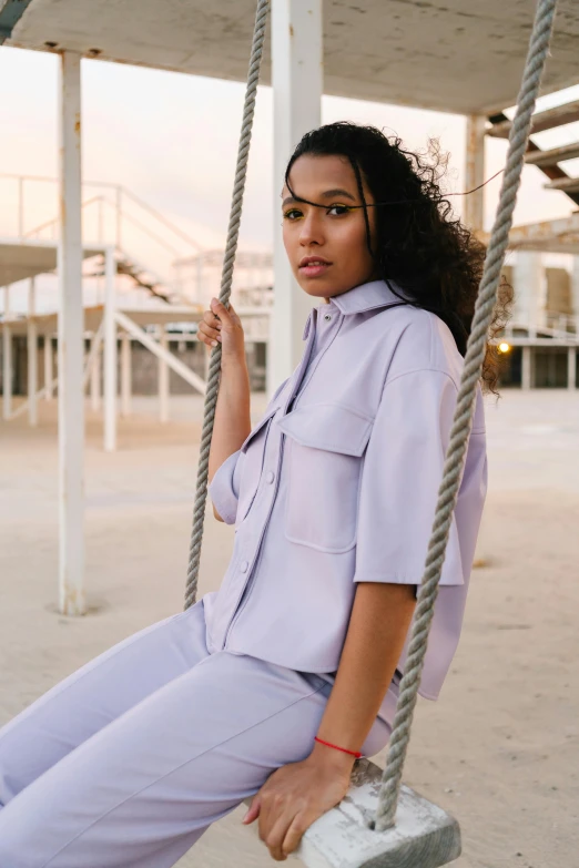 a woman that is sitting on a swing, a portrait, inspired by Esaias Boursse, trending on pexels, light purple, button up shirt, met collection, tonal colors outdoor
