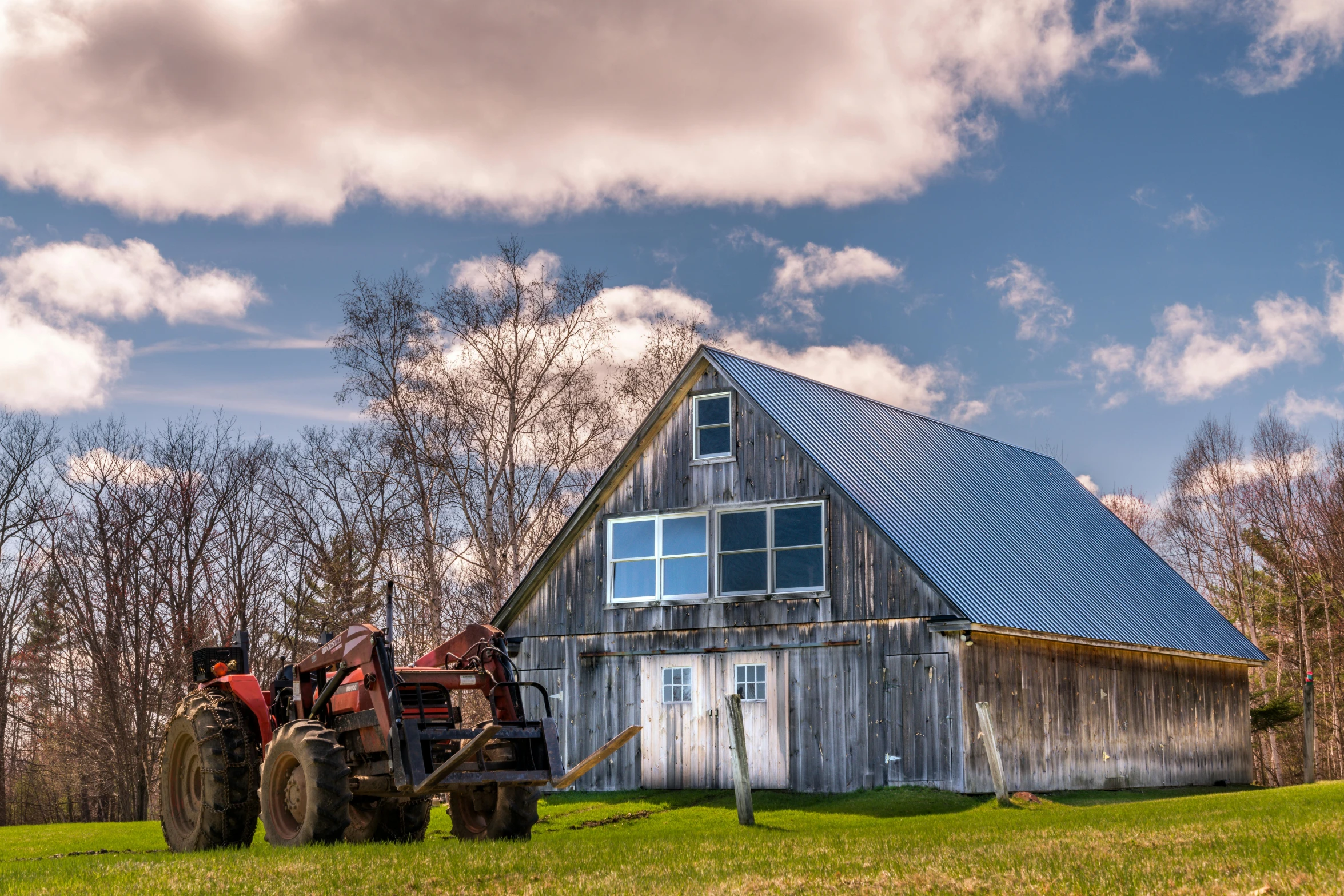 a tractor parked in front of a barn, by Jim Nelson, pexels contest winner, new england architecture, skies behind, afternoon hangout, very high resolution