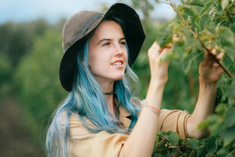 a woman with blue hair picking berries from a tree, inspired by Elsa Bleda, pexels contest winner, handsome girl, with hat, avatar image, 18 years old