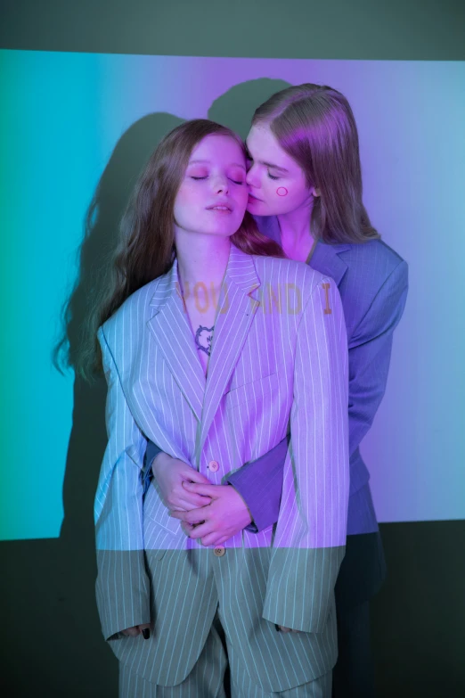 a couple of women standing next to each other, an album cover, by Peter Alexander Hay, trending on pexels, aestheticism, girl in suit, lesbian kiss, sadie sink, model エリサヘス s from acquamodels