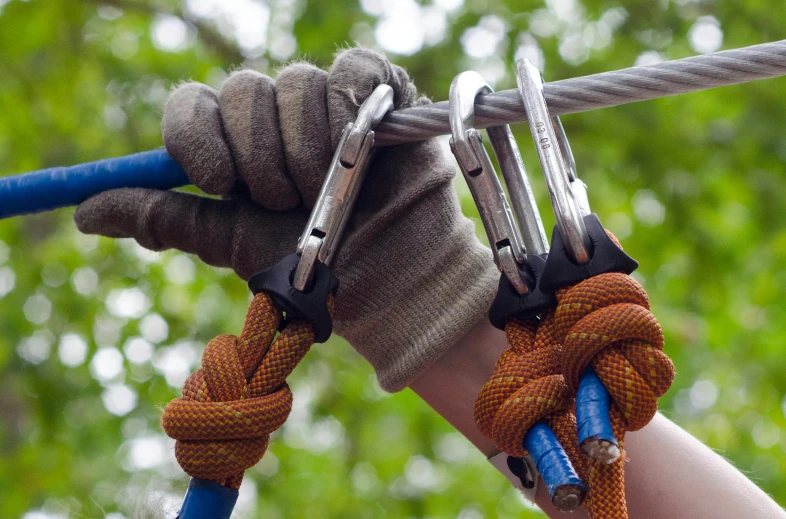 a person holding a pair of scissors on a rope, canopy, wearing gloves, thumbnail, metal claws