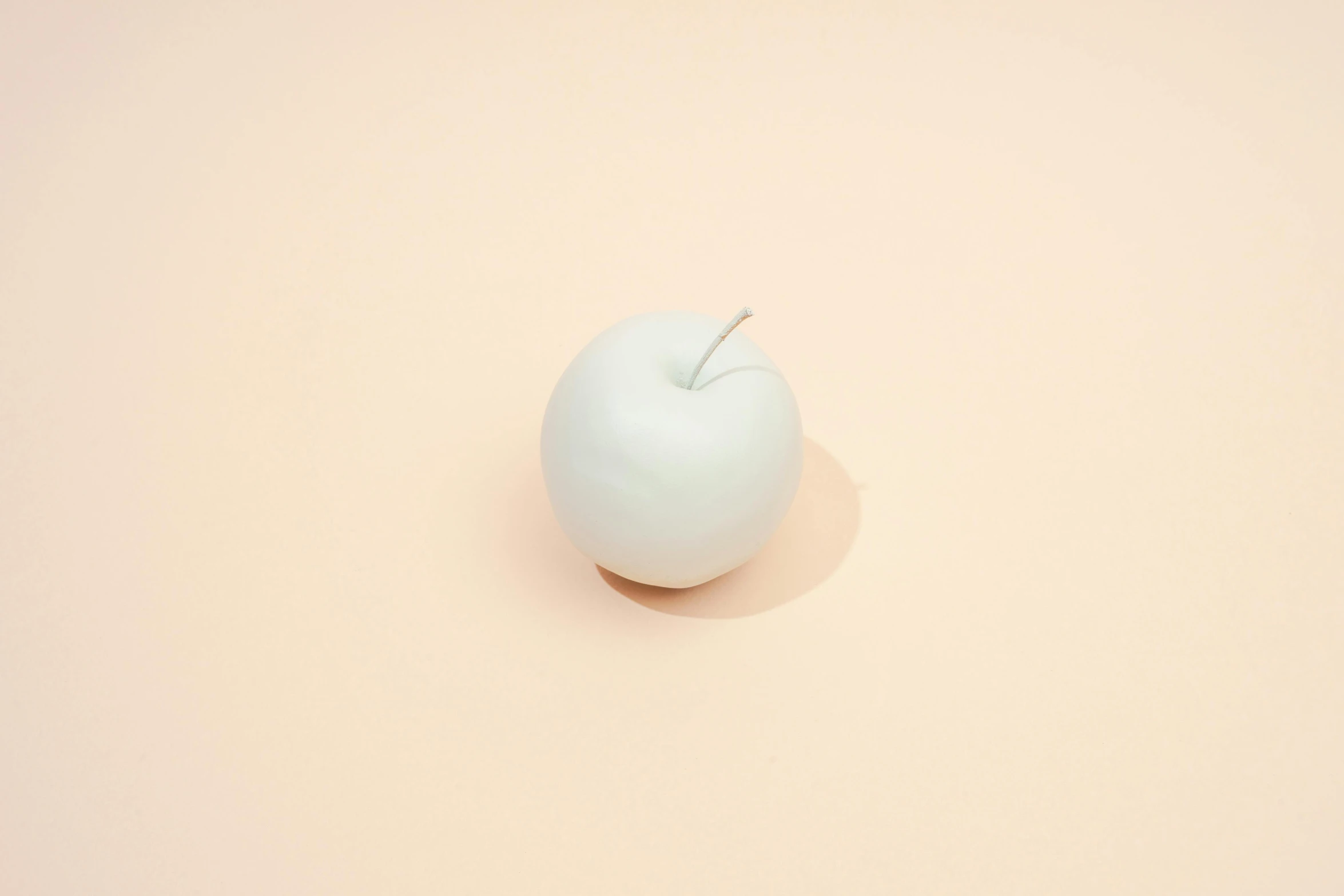 a white apple sitting on top of a pink surface, pale bluish skin, candle, dezeen, full product shot