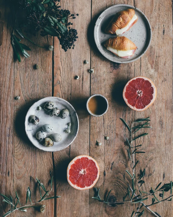 grapefruits and croissants on a wooden table, by Lucia Peka, trending on unsplash, process art, eggs, behance lemanoosh, secret tea society, oysters