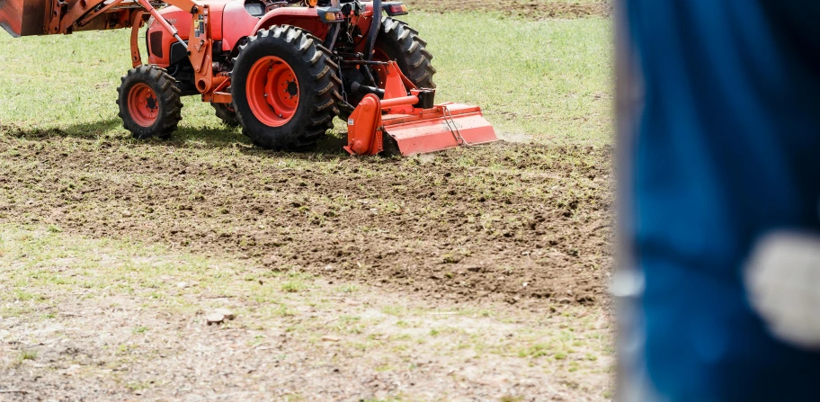 a tractor that is sitting in the dirt, figuration libre, orange grass, pulling weeds out frantically, promo image, close up image