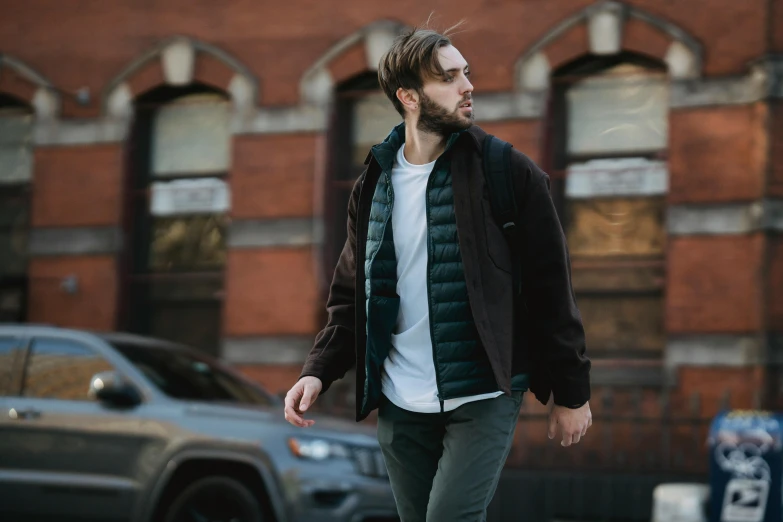 a man riding a skateboard down a street, inspired by Harrington Mann, wearing hunter coat, corduroy, layers on layers on layers, in front of a garage