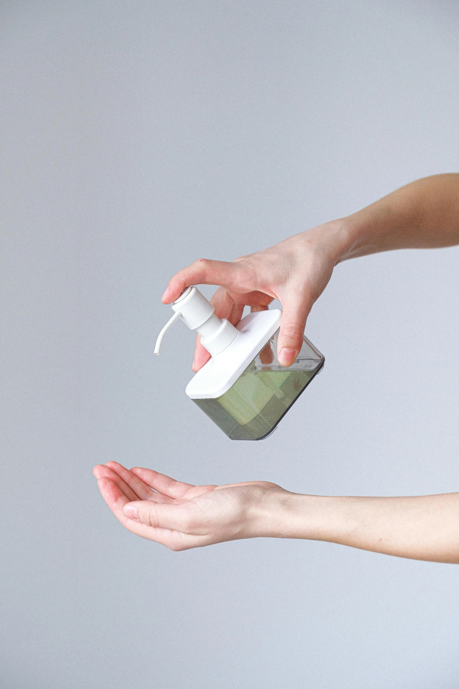 a woman holding a bottle of hand sanitizer, shutterstock, conceptual art, square, without text, soap, procedural