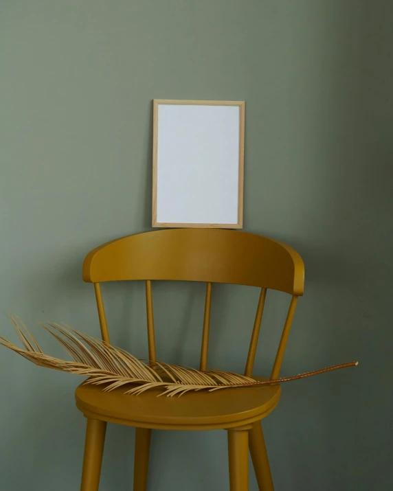 a picture frame sitting on top of a wooden chair, inspired by Martinus Rørbye, featured on pinterest, large leaves, ochre, high quality product photo, very tall