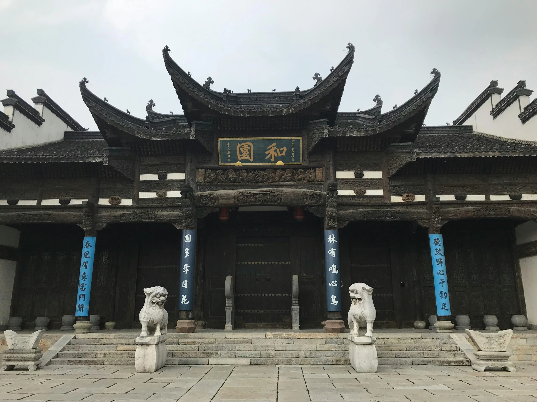 a building with statues in front of it, inspired by Li Di, wooden buildings, with archways, peak experience ”, well preserved