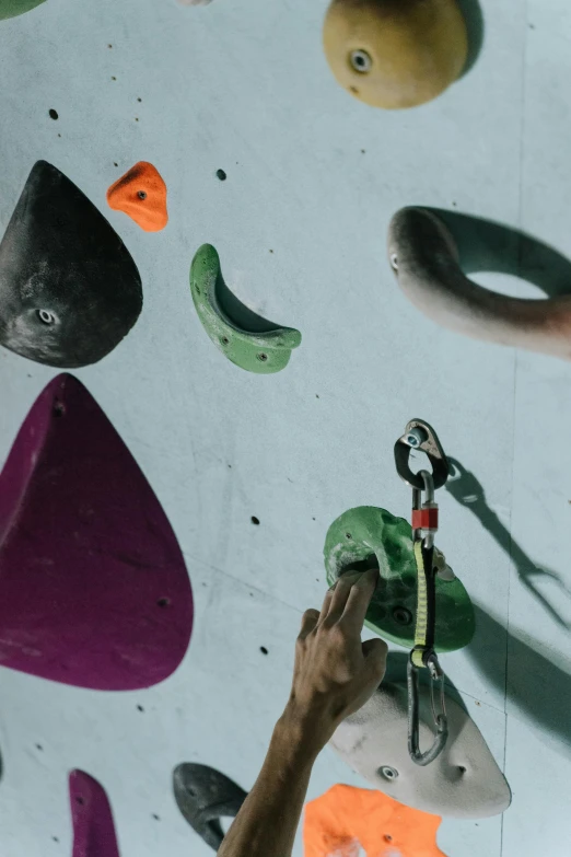 a close up of a person climbing on a wall, rounded shapes, overhead shot, toggles, in a workshop