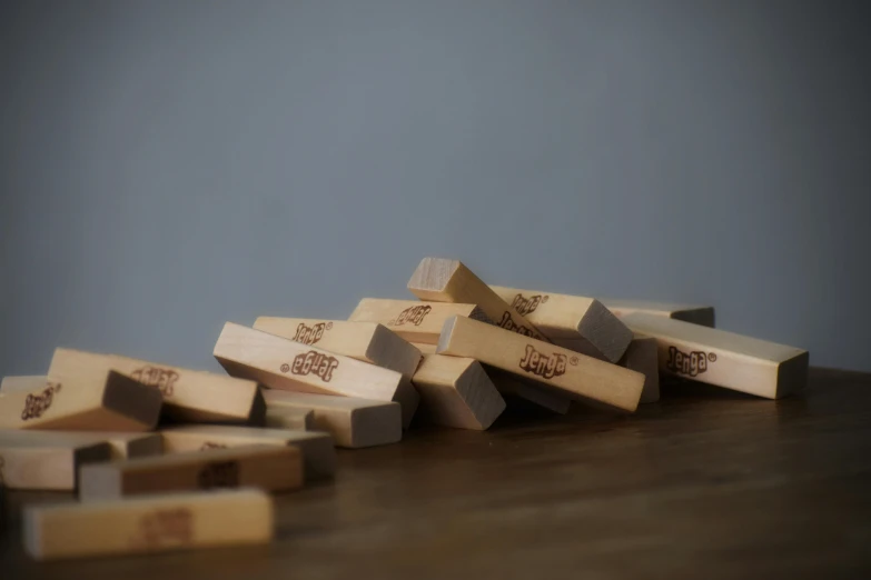 a pile of wooden blocks sitting on top of a table, slapstick, engraved, matt finish, traditional medium