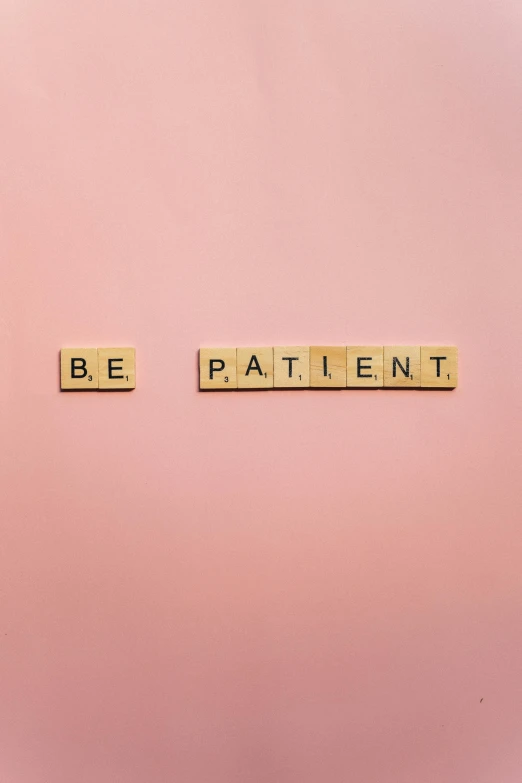 the word be patient spelled in scrabbles on a pink background, a picture, by Irene and Laurette Patten, unsplash, plain walls |light hearted, repeating patterns, award winning on behance, tattoo