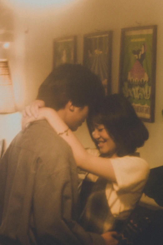 a man standing next to a woman in a living room, a picture, inspired by Nan Goldin, flickr, happening, selena quintanilla perez, 3 5 mm close up, joy ang, grainy movie still