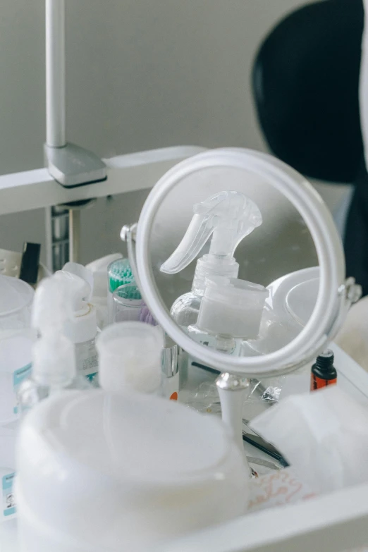 a woman looking at her breast in a mirror, unsplash, plasticien, handling laboratory equipment, white plastic, various items, close - up on detailed