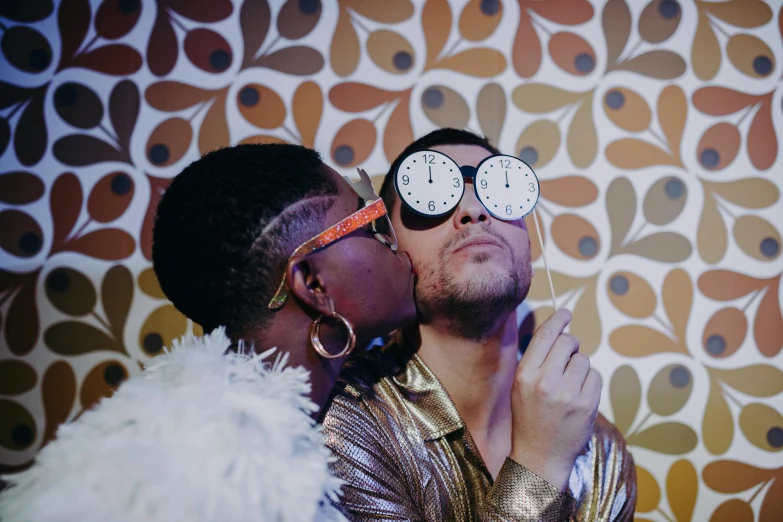 a man and a woman kissing in front of a wall with a clock on it, trending on pexels, funk art, wearing gold glasses, chillin at the club together, queer, darren bartley