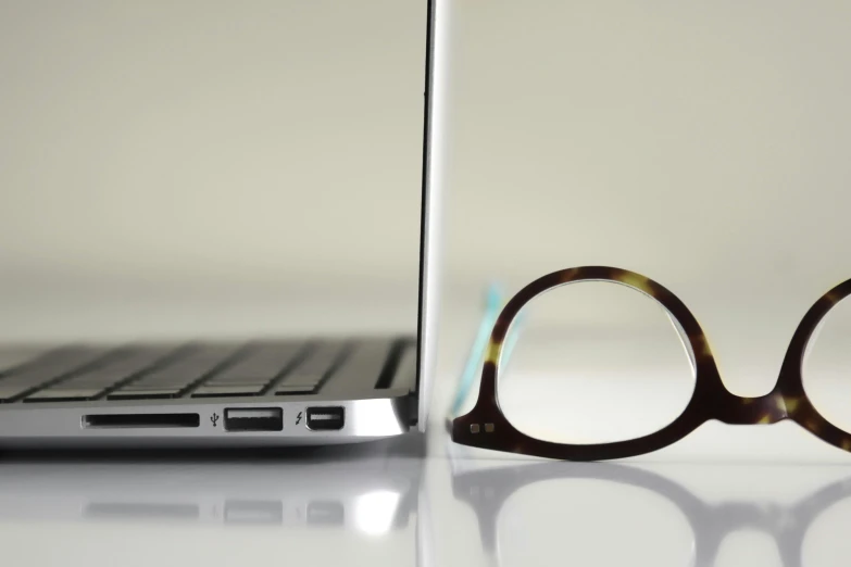 a pair of glasses sitting next to a laptop, ((sharp focus)), product shot, square rimmed glasses, thin dof