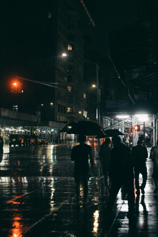 a group of people walking down a street at night, while it's raining, in the middle of new york, unsplash 4k, multiple stories