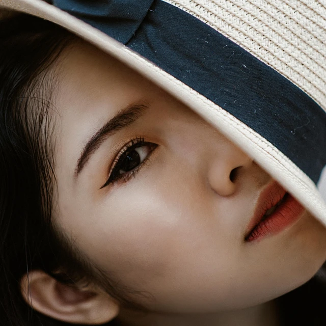 a close up of a person wearing a hat, beutiful face, a high angle shot, asian face, crooked nose
