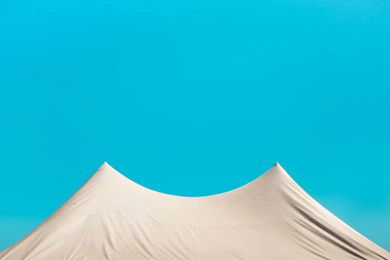 a tent with a blue sky in the background, an album cover, inspired by Christo, unsplash contest winner, postminimalism, tan skin, cyan photographic backdrop, curves, trending on dezeen