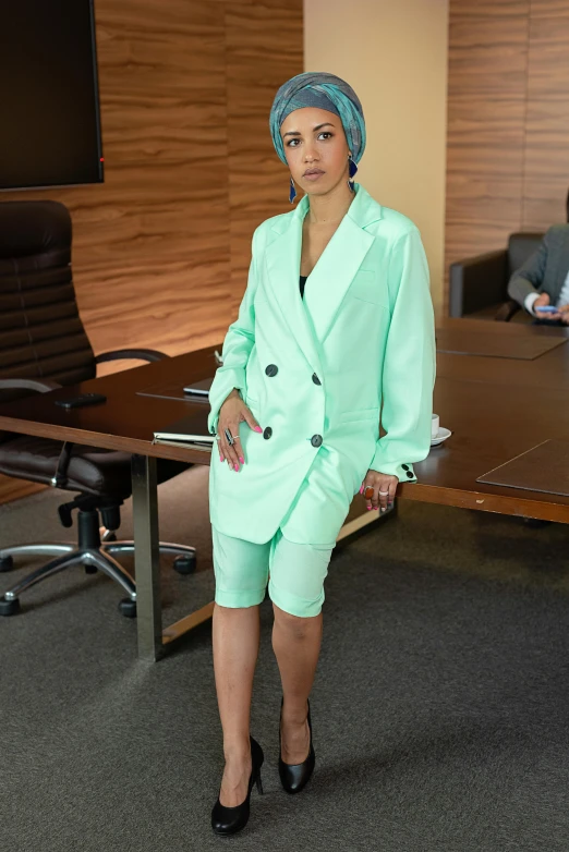 a woman standing in front of a conference table, an album cover, pexels, wearing green suit, wearing a light blue suit, full body shot 4k, female in office dress