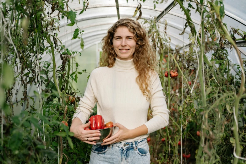 a woman holding a bowl of tomatoes in a greenhouse, a portrait, inspired by Elsa Beskow, pexels contest winner, portrait of tall, wearing a red turtleneck sweater, jodie whittaker, portrait image