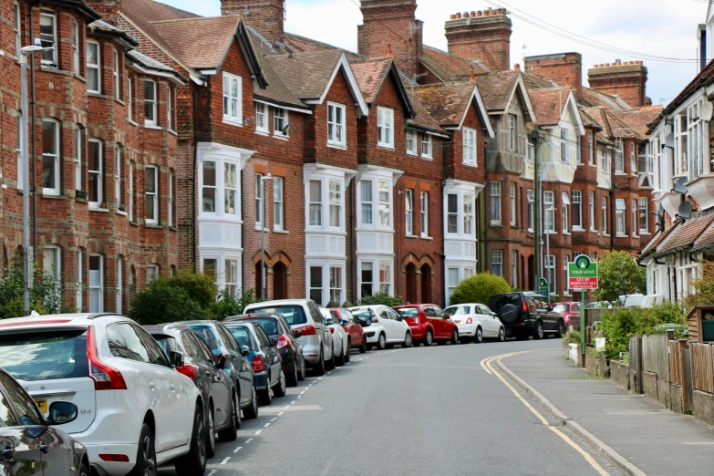 a row of parked cars on a city street, arts and crafts movement, red bricks, delightful surroundings, hospital, bright castleton green