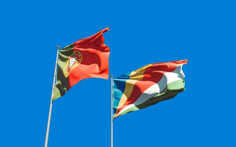 two flags blowing in the wind against a blue sky, by Julian Hatton, shutterstock, hurufiyya, portugal, square, avatar image, multi - coloured