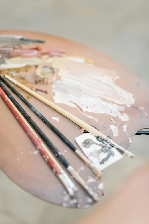 a close up of a person holding a paint palette, a photorealistic painting, inspired by Julian Schnabel, trending on unsplash, drawing an arrow from his quiver, resin and clay art, multiple brush strokes, oil on canvas high angle view