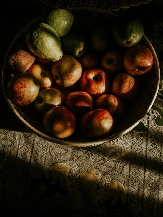 a bowl of apples and pears sitting on a table, inspired by Elsa Bleda, unsplash contest winner, renaissance, dimly lit, late summer evening, 🐿🍸🍋, historical picture