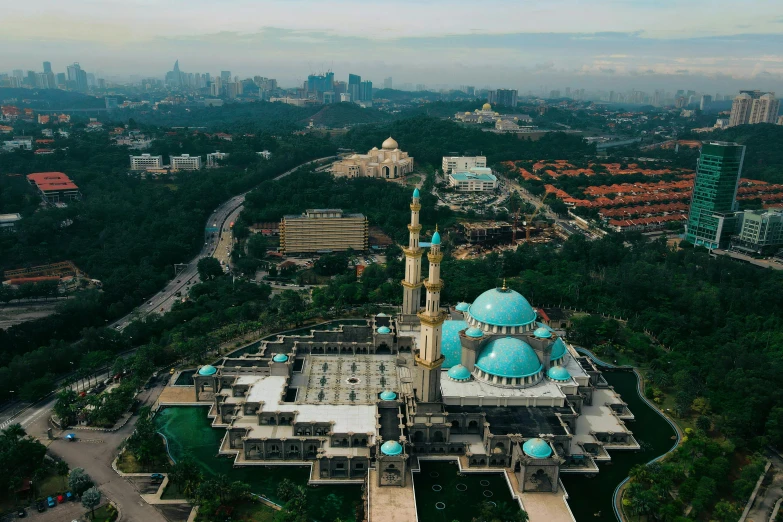 an aerial view of a mosque in the middle of a city, a detailed matte painting, by Basuki Abdullah, pexels contest winner, hurufiyya, a massive cathedral in a forrest, malaysian, teal aesthetic, beeple and james jean