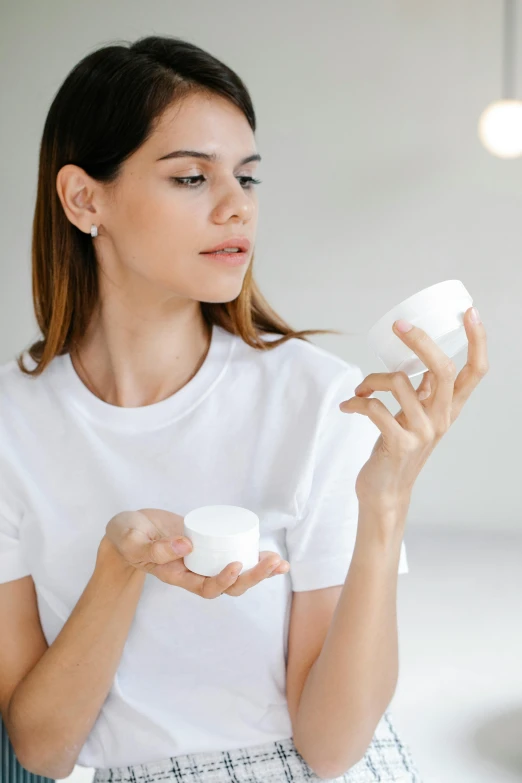 a woman holding a jar of cream in her hands, trending on pexels, looking left, avatar image, silicone skin, inspect in inventory image