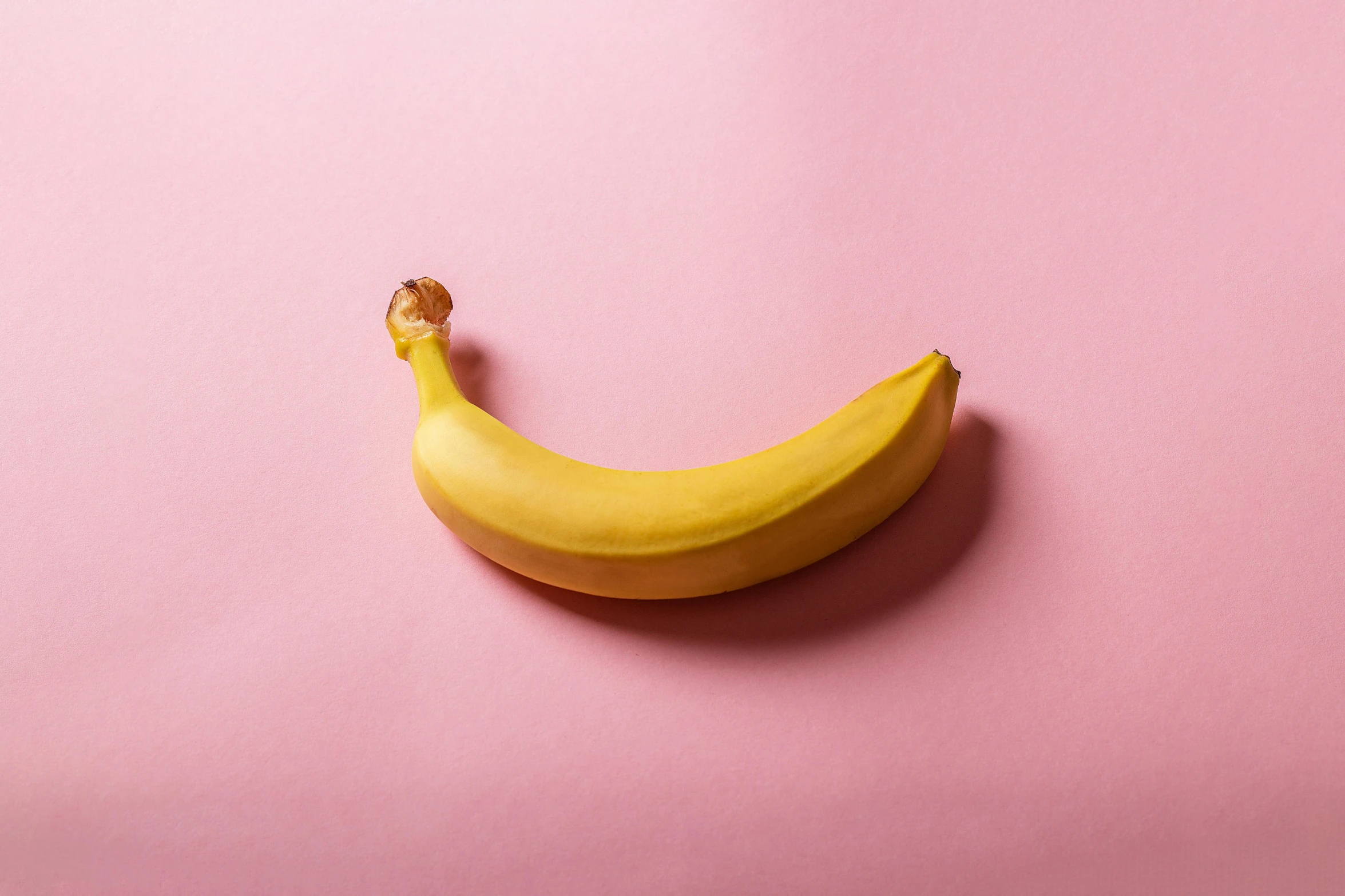 a banana sitting on top of a pink surface, inspired by Sarah Lucas, trending on pexels, visible stomach, contracept, vibrating, male and female