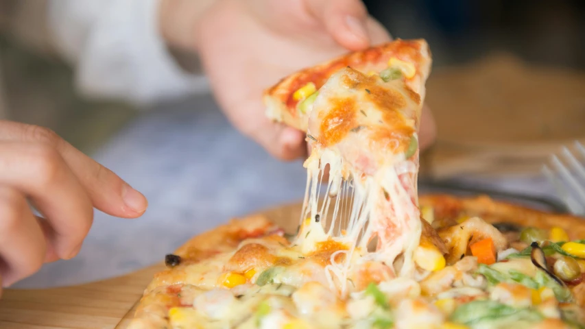 a person taking a slice of pizza with a fork, by Tom Bonson, pexels, covered in white flour, lachlan bailey, extra cheese, local close up