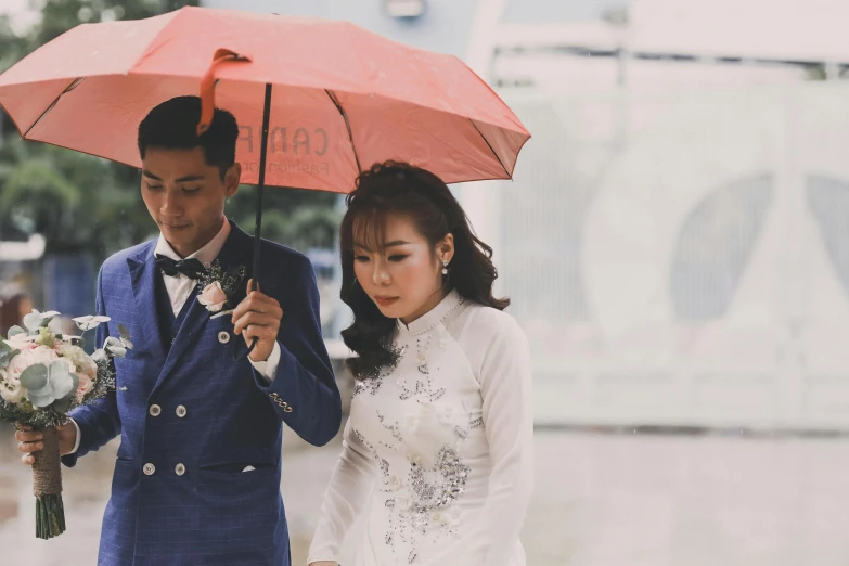 a man and a woman standing under an umbrella, a colorized photo, inspired by Cui Bai, pexels contest winner, ceremony, youtube thumbnail, vietnamese woman, grey