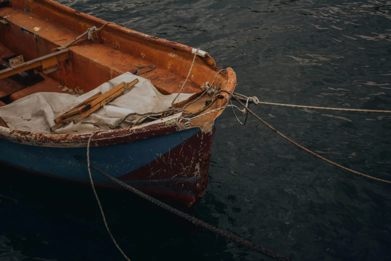 a boat tied to a rope in a body of water, by Elsa Bleda, pexels contest winner, renaissance, brown, thumbnail, navy, skiff