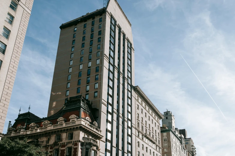 a tall building sitting in the middle of a city, by Adam Saks, unsplash, art nouveau, concrete building, harlem, slide show, neoclassicism style