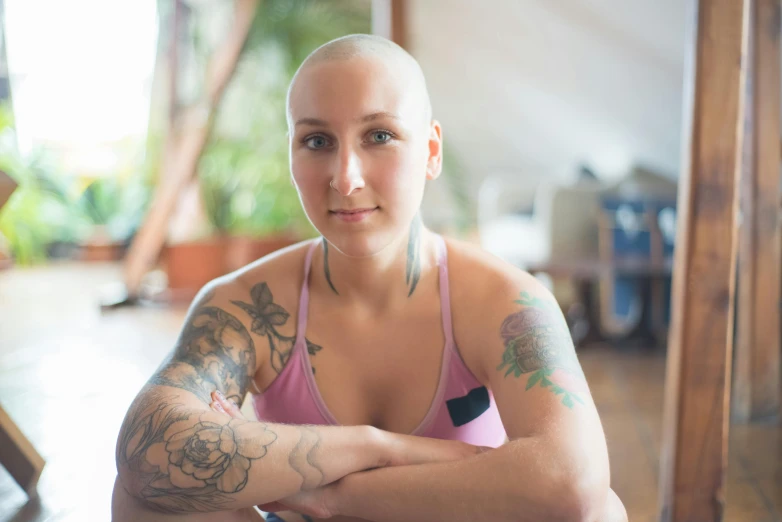 a woman with tattoos is posing for a picture, a portrait, by Jessie Alexandra Dick, pexels contest winner, partially bald, padmasana, half - length photo, avatar image