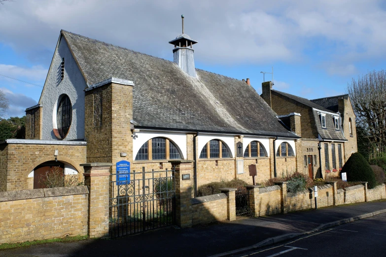 a church with a steeple and a clock tower, an album cover, by Helen Stevenson, unsplash, barbizon school, taken from the high street, elevation view, “ golden chalice, with archways