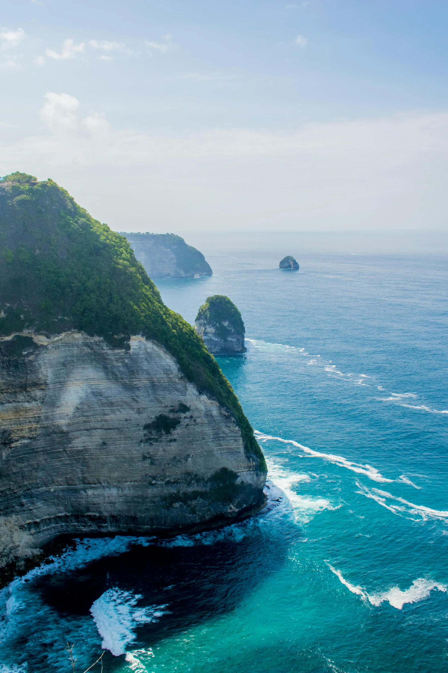 a large body of water next to a cliff, happening, bali, rock arcs, towering high up over your view, slide show