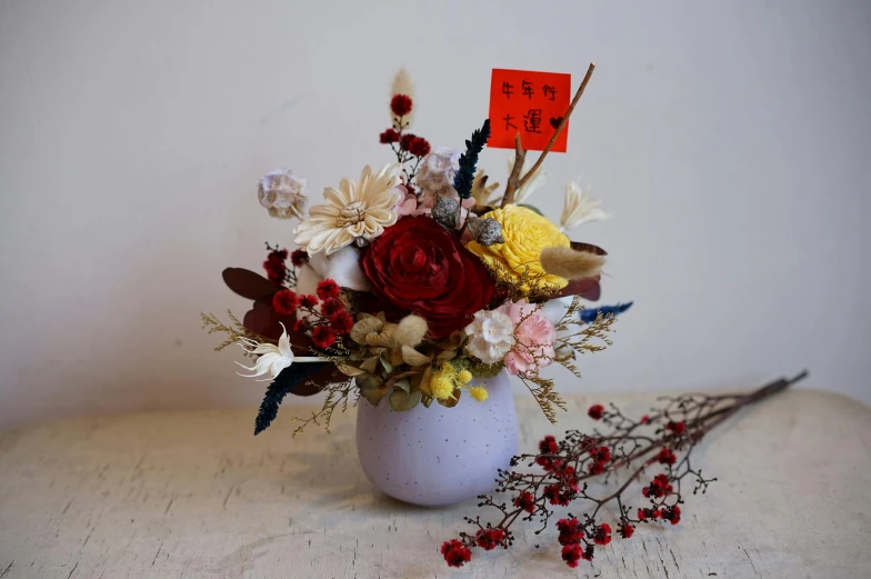 a vase filled with flowers on top of a table, inspired by Cui Bai, unsplash, made of colorful dried flowers, red and white flowers, 中 国 鬼 节, small in size