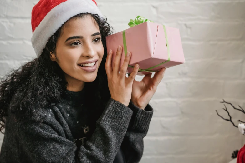 a woman in a santa hat holding a pink present, pexels contest winner, happening, square, avatar image, teen elf girl, black