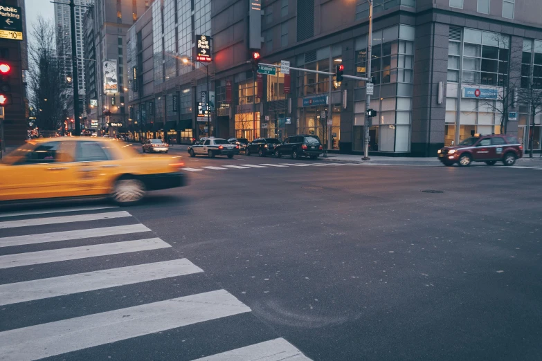 a yellow taxi driving down a street next to tall buildings, pexels contest winner, crosswalks, early evening, thumbnail, manhattan