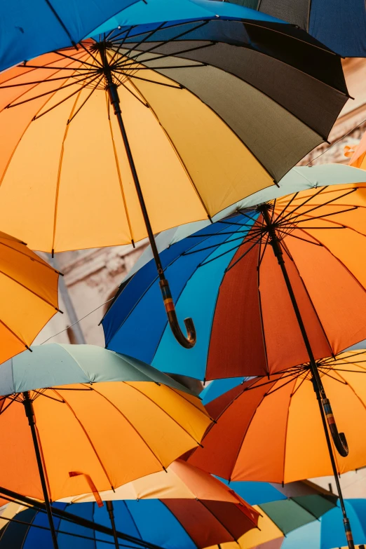 a bunch of colorful umbrellas hanging from the ceiling, a cartoon, inspired by Christo, trending on unsplash, brown, detail shot, multiple stories, orange and blue