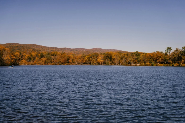 a large body of water surrounded by trees, inspired by Sanford Robinson Gifford, unsplash, hudson river school, ignant, fall season, 2000s photo, zoomed in shots