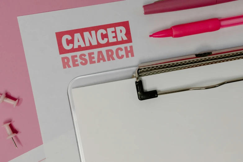 a piece of paper sitting on top of a clipboard, by Rachel Reckitt, the cure for cancer, some pink, logo for research lab, high quality photo