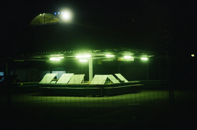 a gazebo lit up at night in the dark, a hologram, unsplash, graffiti, detention centre, 1 9 8 5 photograph, turbines, bus station