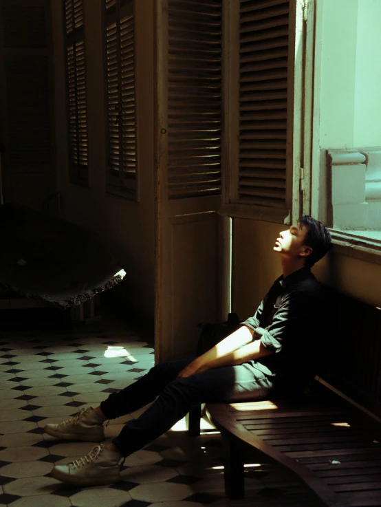 a man sitting on a bench in front of a window, by Elsa Bleda, pexels contest winner, hyperrealism, some sunlight ray, relaxed pose, profile pic, ( ( theatrical ) )