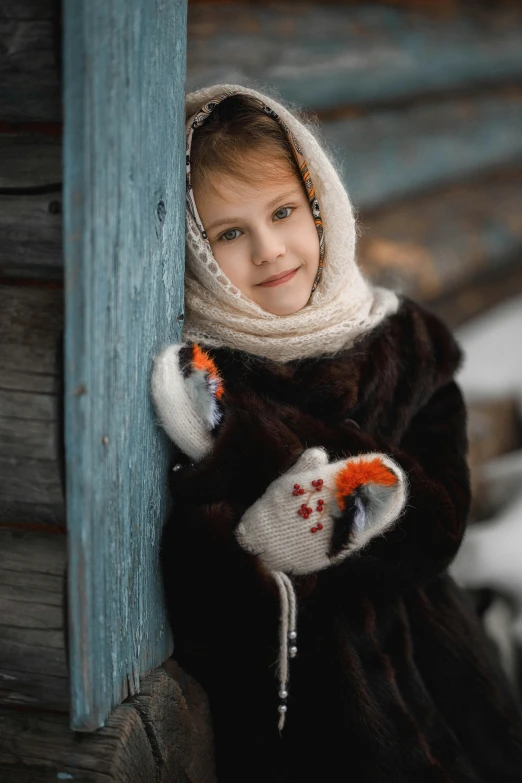 a little girl that is leaning against a wall, by Ivan Grohar, pexels contest winner, mittens, russian village, (3 are winter, square
