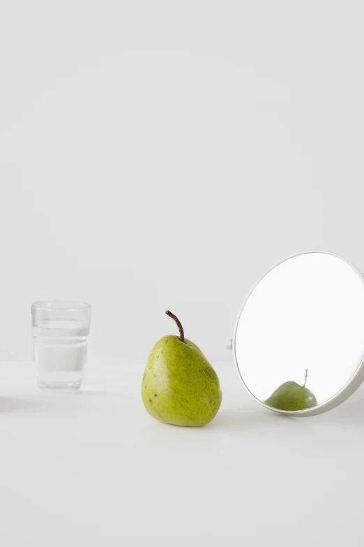 a pear and a glass of water on a table, by Doug Ohlson, round mirror on the wall, clean white lab background, alex kanevsky, product view