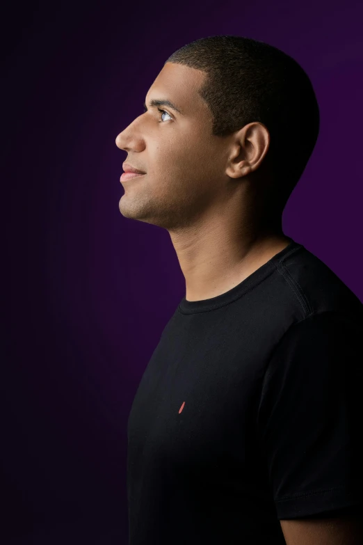 a man standing in front of a purple background, wearing a black tshirt, profile portrait, joseph moncada, young prince