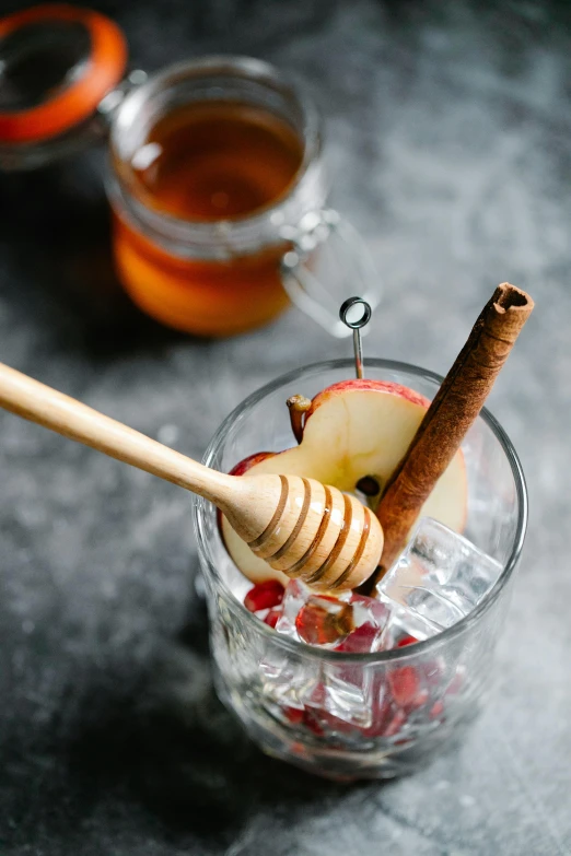 an apple and cinnamon stick in a glass of water, by Julia Pishtar, trending on pexels, honeycomb, square, bartending, grey